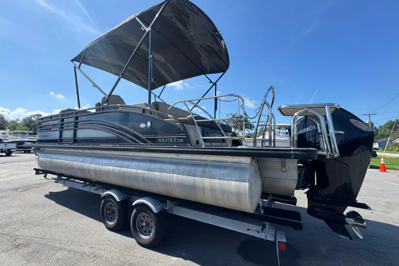 Slide: The Image of 2021 Harris Solstice 230 pontoon boat on trailer, featuring a canopy and Mercury outboard motor. - 5