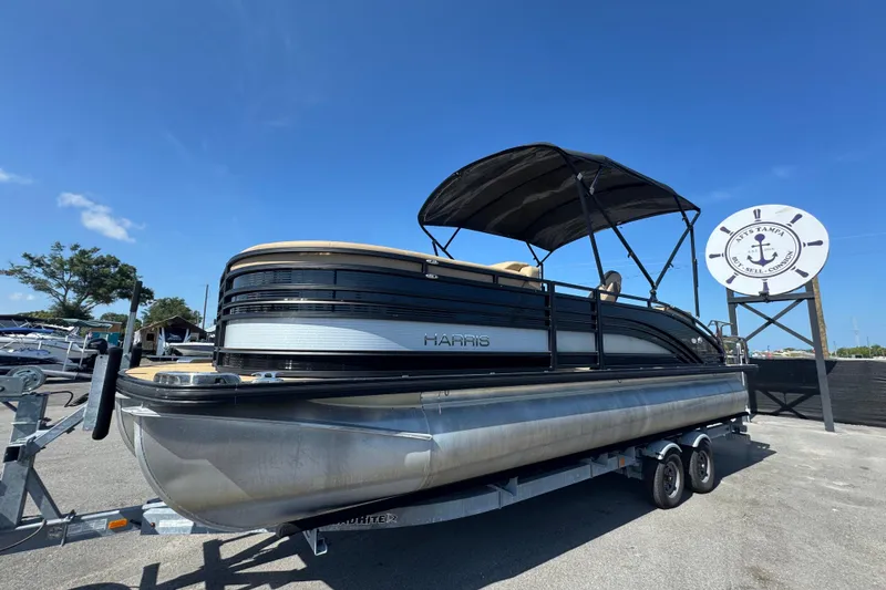 Slide: The Image of 2021 Harris Solstice 230 pontoon boat on trailer under clear blue sky. - 7