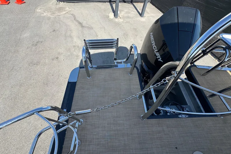 Slide: The Image of 2021 Harris Solstice 230 boat with Mercury engine, featuring a sleek rear deck and ladder. - 29