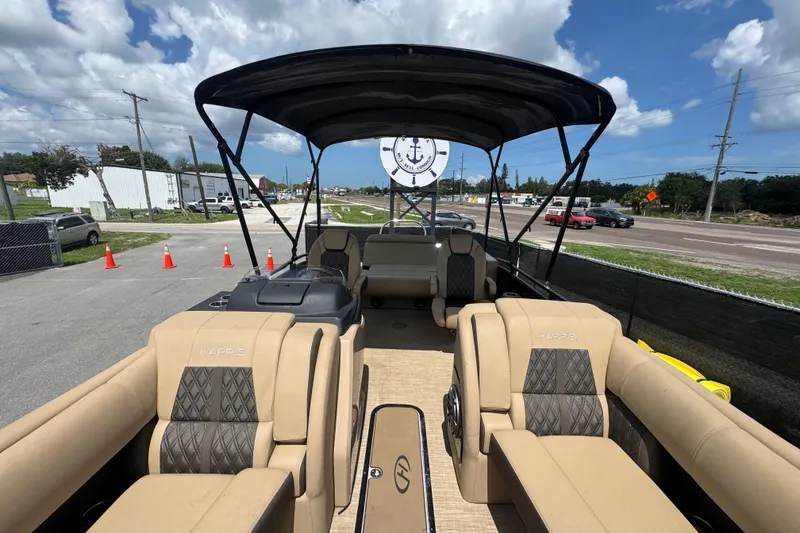 Slide: The Image of 2021 Harris Solstice 230 pontoon boat with beige seating and black canopy. - 11