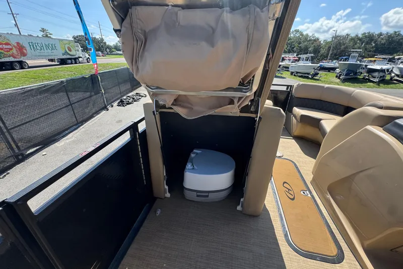 Slide: The Image of 2021 Harris Solstice 230 boat interior with portable toilet and seating area. - 45