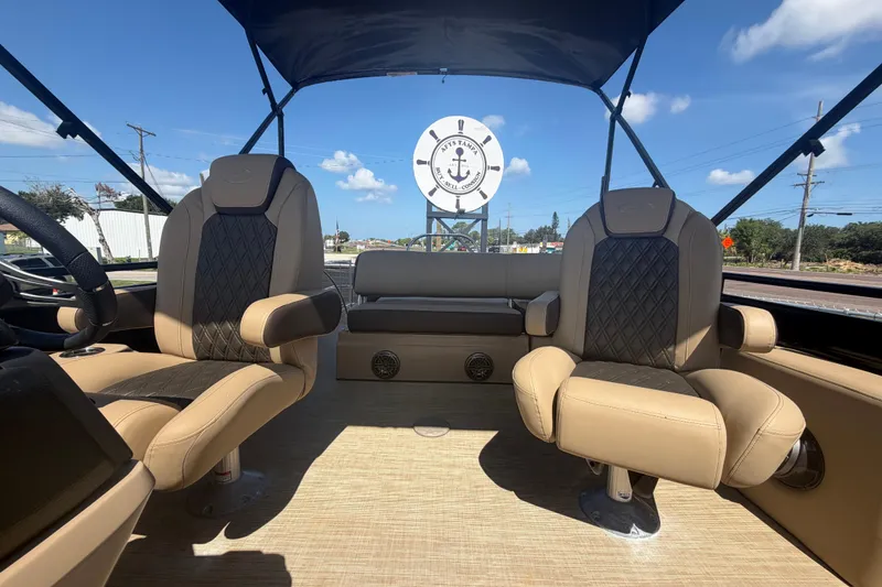 Slide: The Image of 2021 Harris Solstice 230 boat interior with beige seating and canopy under blue sky. - 14