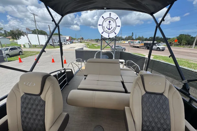 Slide: The Image of 2021 Harris Solstice 230 boat interior with beige seating and open canopy. - 15