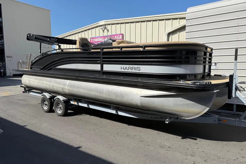 The Image of 2021 Harris Solstice 230 pontoon boat on trailer, parked outside a storage facility. - 0