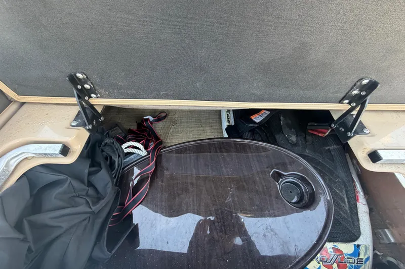 Slide: The Image of An open storage compartment on a boat with various items, including cables and a cover. - 39