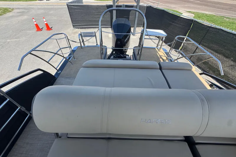 Slide: The Image of 2021 Harris Solstice 230 boat with plush seating and sleek design, parked outdoors. - 26