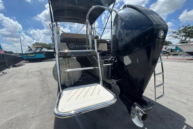 Slide: The Image of 2021 Harris Solstice 230 boat with powerful outboard motor and swim platform under a sunny sky. - 66