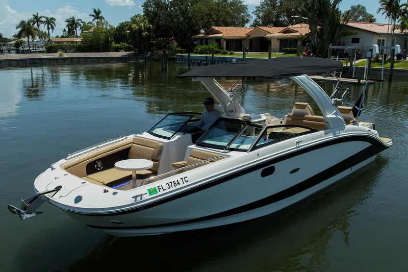Slide: The Image of 2022 Sea Ray SDX 290 boat docked on calm water near waterfront homes. - 17