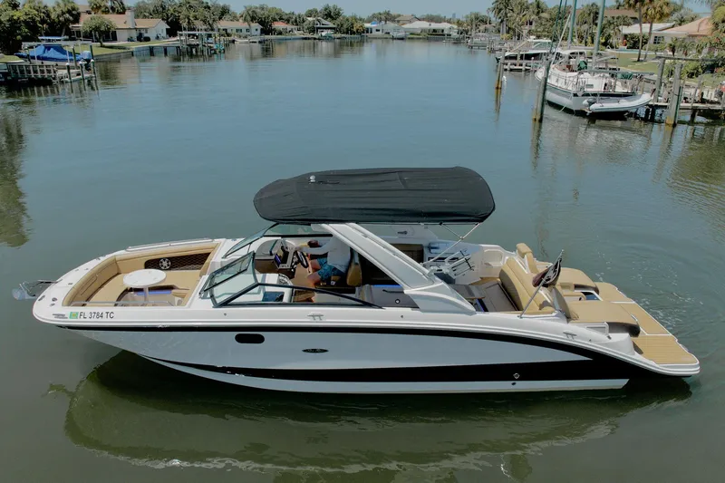 Slide: The Image of 2022 Sea Ray SDX 290 boat cruising on a calm waterway, featuring sleek design and spacious seating. - 7