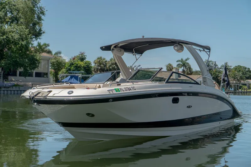 Slide: The Image of 2022 Sea Ray SDX 290 boat on calm water, surrounded by lush greenery. - 1