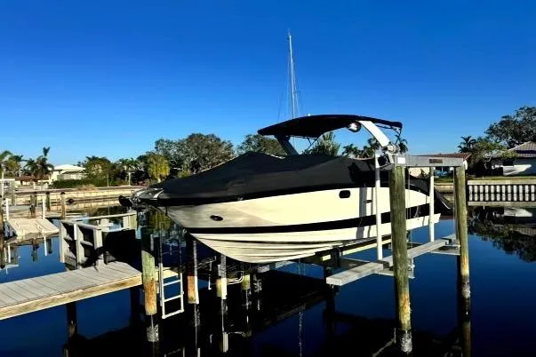 Slide: The Image of 2022 Sea Ray SDX 290 boat docked on a lift in a serene marina. - 62