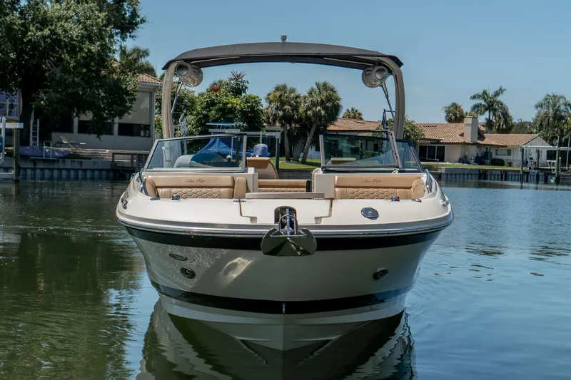 Slide: The Image of 2022 Sea Ray SDX 290 boat on calm water, surrounded by waterfront homes. - 4