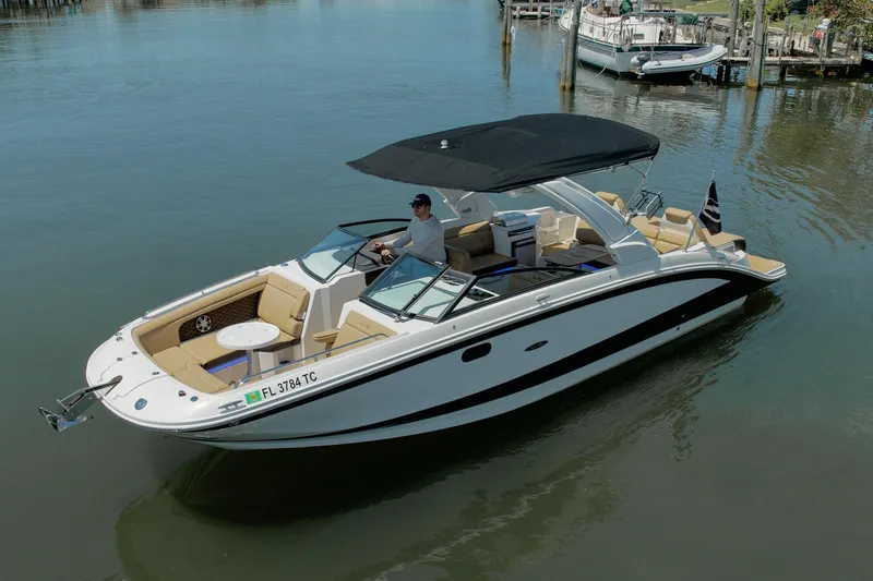 The Image of 2022 Sea Ray SDX 290 boat cruising on calm water with a black canopy. - 0