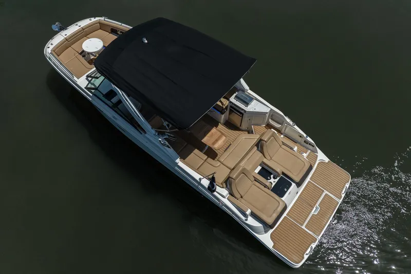 Slide: The Image of 2022 Sea Ray SDX 290 boat with black canopy and spacious seating on water. - 13