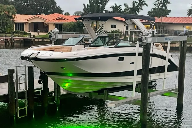 Slide: The Image of 2022 Sea Ray SDX 290 boat on lift, illuminated by green underwater lights. - 63