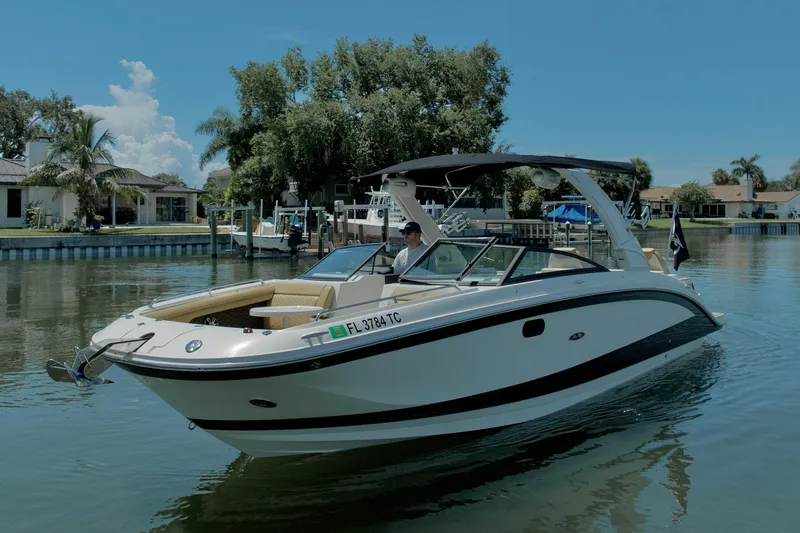 Slide: The Image of 2022 Sea Ray SDX 290 boat cruising on a calm waterway, surrounded by lush greenery. - 3