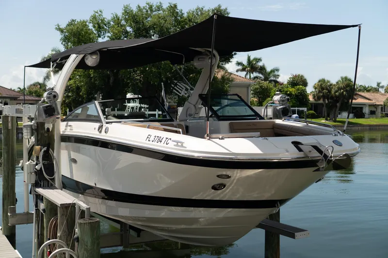 Slide: The Image of 2022 Sea Ray SDX 290 boat docked with canopy, surrounded by waterfront homes. - 18