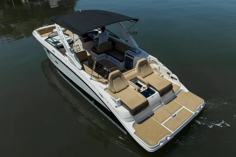 Slide: The Image of 2022 Sea Ray SDX 290 boat with tan seating and black canopy on calm water. - 8