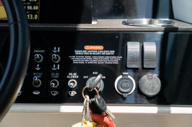 Slide: The Image of Control panel of 2022 Sea Ray SDX 290 boat with warning label and switches. - 43
