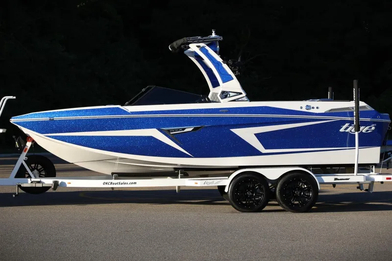 Slide: The Image of 2024 Tigé 22RZX boat in blue and white on a trailer. - 9