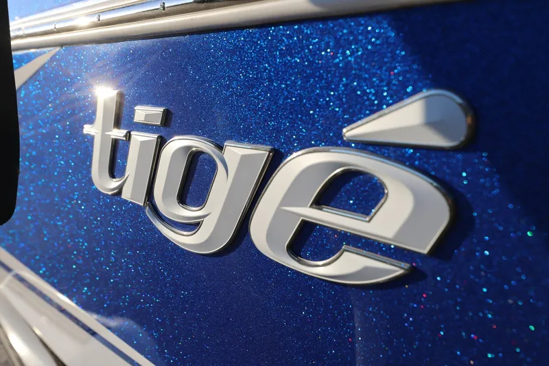 Slide: The Image of 2024 Tigé 22RZX boat logo on sparkling blue surface. - 14