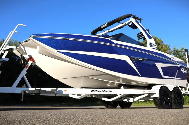 Slide: The Image of 2024 Tigé 22RZX boat on trailer, featuring sleek blue and white design. - 5
