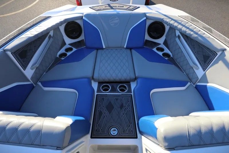 Slide: The Image of 2024 Tigé 22RZX boat interior with blue and gray seating, cup holders, and speakers. - 10