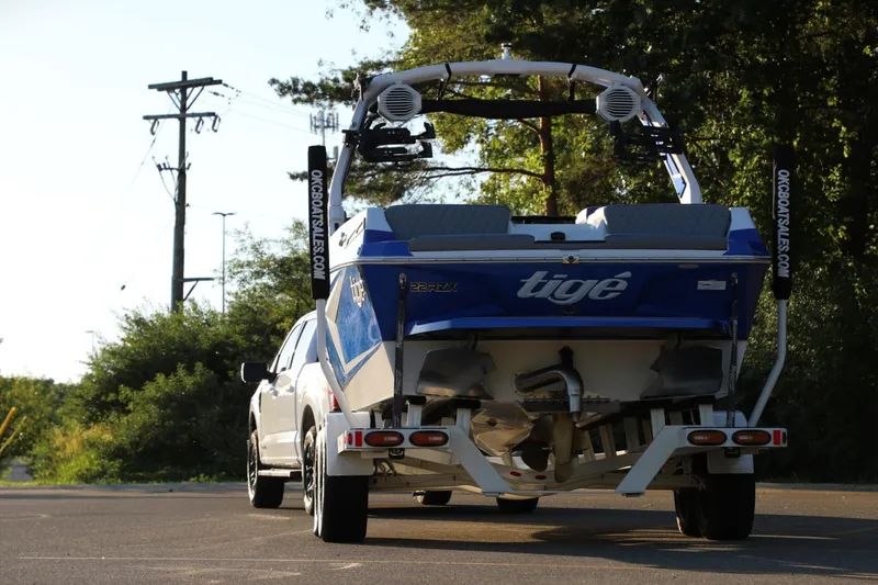 Slide: The Image of 2024 Tigé 22RZX boat on trailer, parked outdoors, rear view. - 7