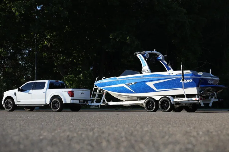 Slide: The Image of White truck towing a blue 2024 Tigé 22RZX boat on a trailer. - 3