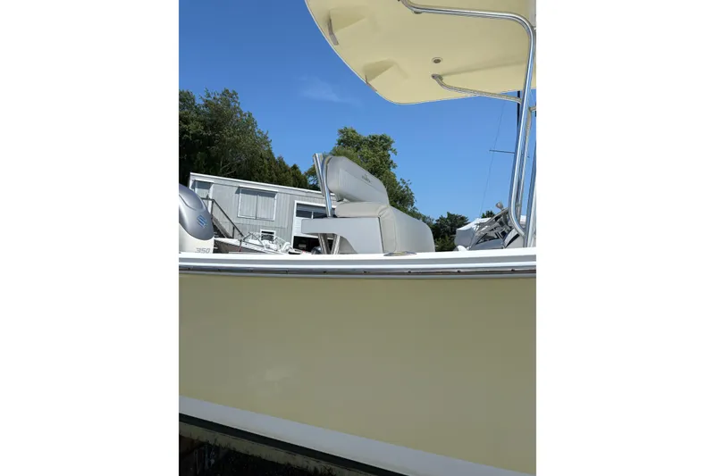 Slide: The Image of 2008 Regulator 23 Forward Seating boat with canopy and seating, parked outdoors. - 5