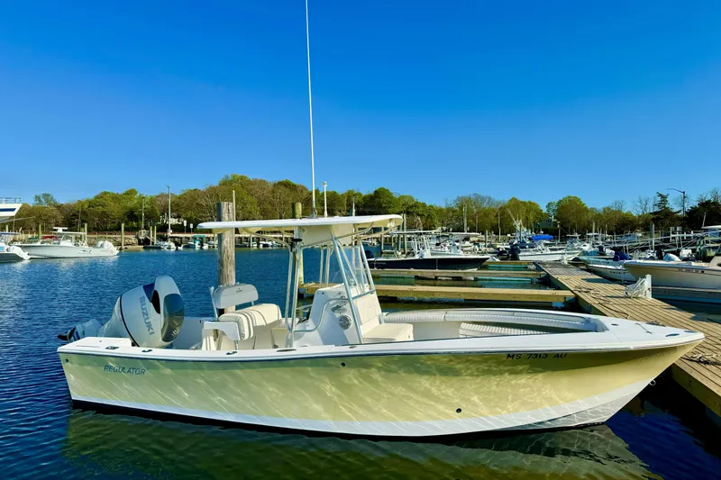 The Image of 2008 Regulator 23 Forward Seating boat docked in a marina under clear blue skies. - 0