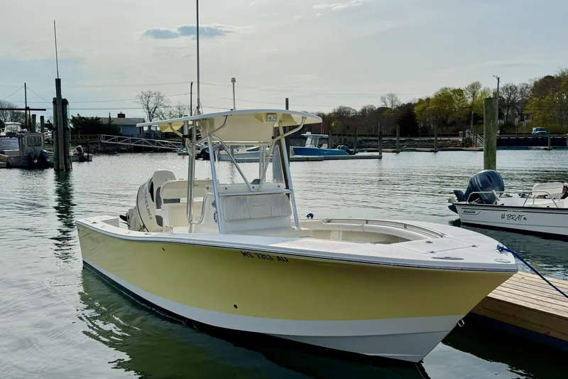 Slide: The Image of 2008 Regulator 23 Forward Seating boat docked in a serene marina setting. - 2