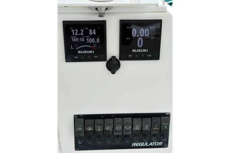 Slide: The Image of Console of 2008 Regulator 23 Forward Seating boat with Suzuki engine displays and controls. - 13