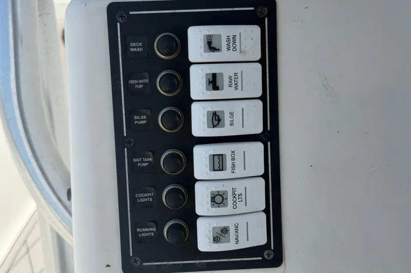 Slide: The Image of Control panel of a 2006 Pro Sports 2550 BW boat with labeled switches. - 28