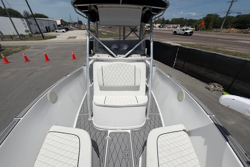 Slide: The Image of 2006 Pro Sports 2550 BW boat interior with white cushioned seating and open deck. - 49