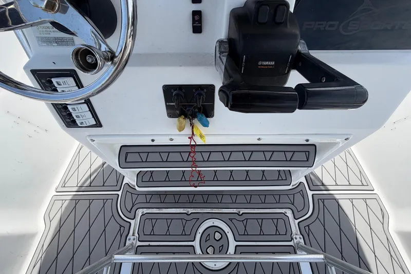 Slide: The Image of Control panel of a 2006 Pro Sports 2550 BW boat with steering wheel and throttle. - 27