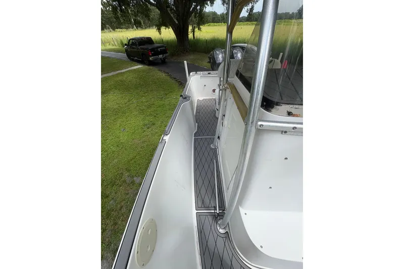 Slide: The Image of 2006 Pro Sports 2550 BW boat with sleek deck design, parked near a grassy area. - 11