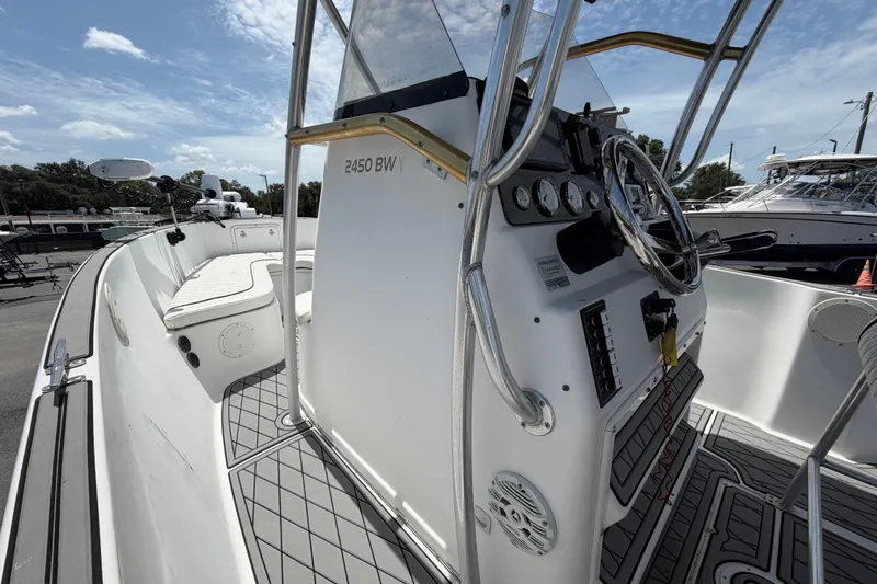 Slide: The Image of 2006 Pro Sports 2550 BW boat interior with steering console and seating, under a clear sky. - 30