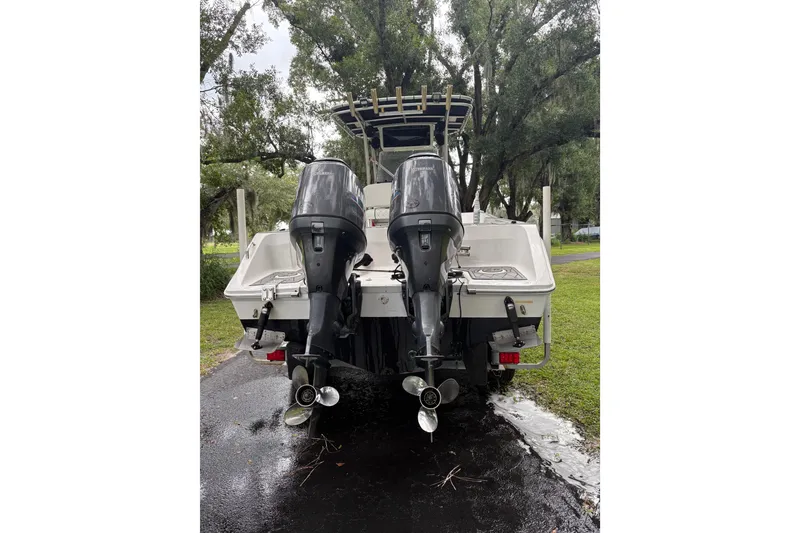 Slide: The Image of 2006 Pro Sports 2550 BW boat with dual outboard motors, parked on a wet driveway. - 22