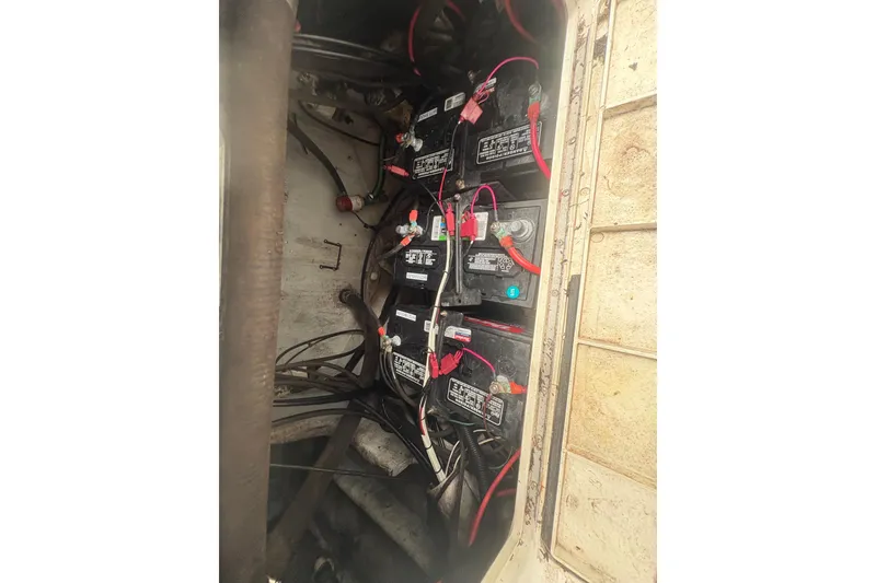 Slide: The Image of Battery compartment of a 2006 Pro Sports 2550 BW boat with multiple batteries and wiring. - 27