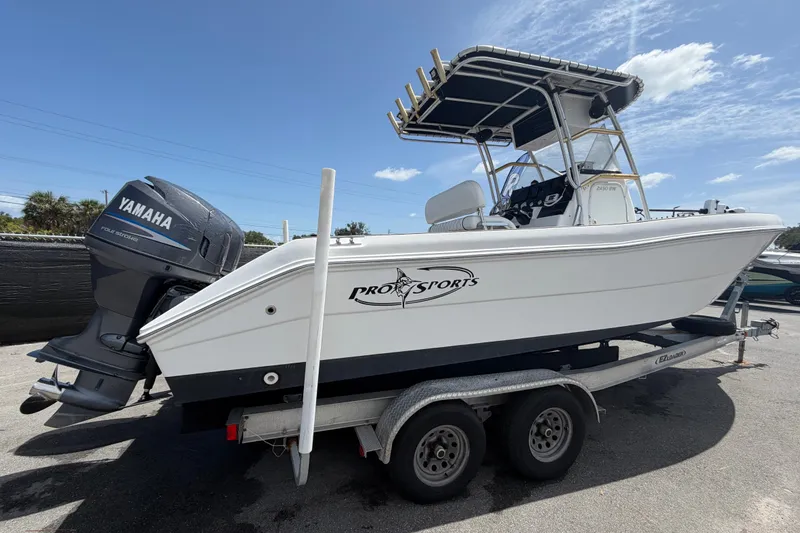 Slide: The Image of 2006 Pro Sports 2550 BW boat on trailer with Yamaha outboard motor under clear sky. - 2