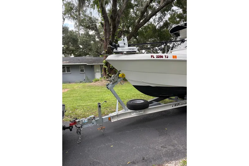 Slide: The Image of Trailered 2006 Pro Sports 2550 BW boat parked on driveway near house. - 1