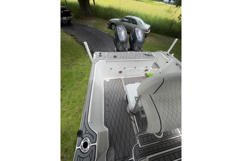 Slide: The Image of 2006 Pro Sports 2550 BW boat with dual engines, parked on grass near a driveway. - 12