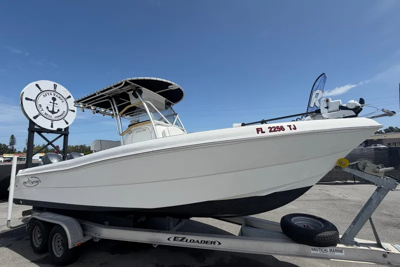 The Image of 2006 Pro Sports 2550 BW boat on trailer at dealership under clear sky. - 0