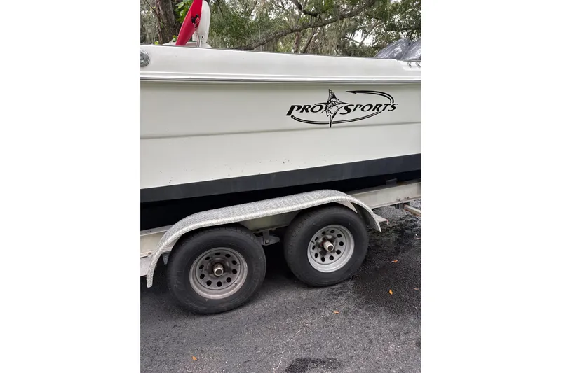 Slide: The Image of Trailer with 2006 Pro Sports 2550 BW boat, parked on asphalt, featuring logo and dual wheels. - 3