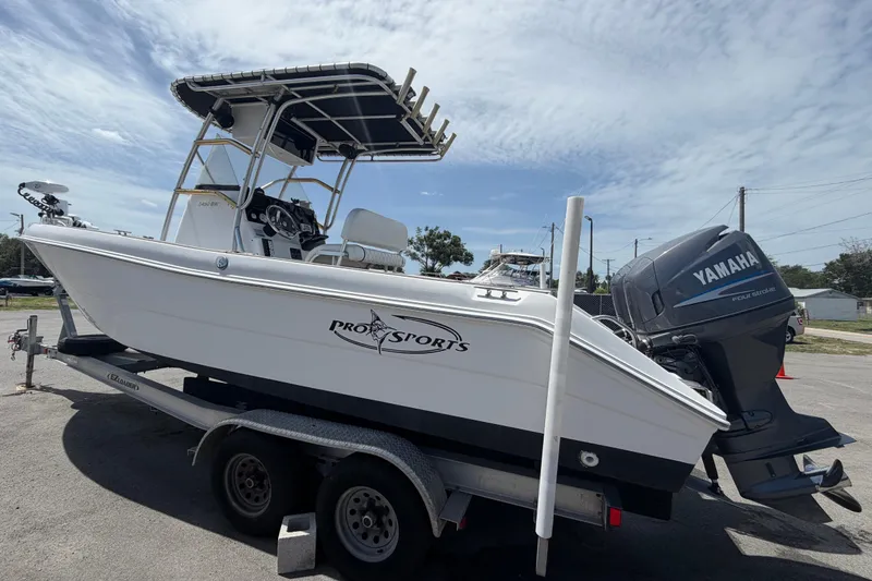 Slide: The Image of 2006 Pro Sports 2550 BW boat on trailer with Yamaha outboard motor, parked outdoors. - 9