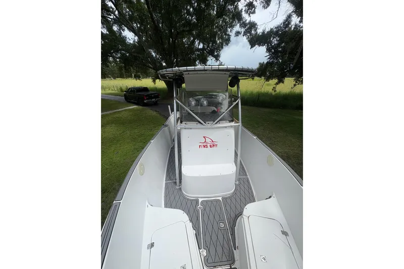 Slide: The Image of 2006 Pro Sports 2550 BW boat with center console, parked on grassy area. - 9