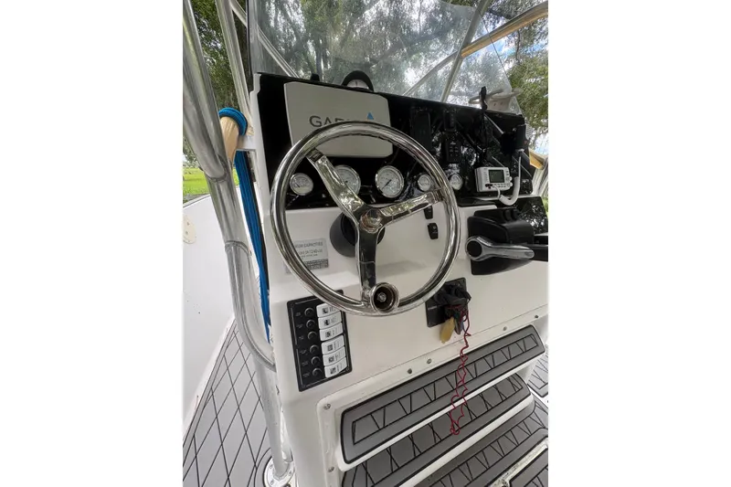 Slide: The Image of Center console of a 2006 Pro Sports 2550 BW boat with steering wheel and controls. - 8