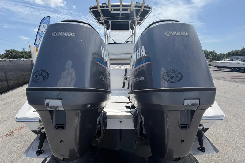 Slide: The Image of Twin Yamaha outboard engines on a 2006 Pro Sports 2550 BW boat, parked outdoors. - 4