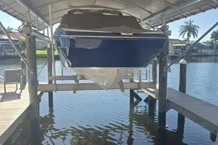 Slide: The Image of 2016 Yamaha Boats 242 Limited S E-Series on lift, docked by waterfront. - 1